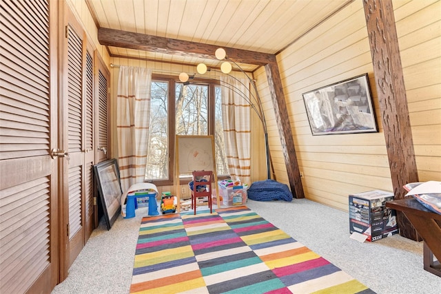 game room featuring wooden ceiling, carpet flooring, beamed ceiling, and wooden walls