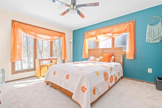 bedroom with baseboards, a ceiling fan, and light colored carpet