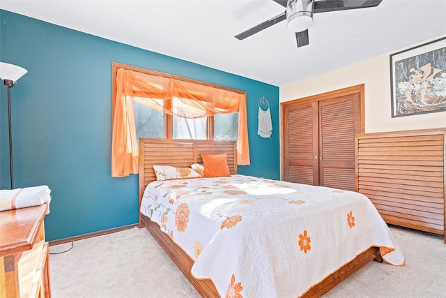 bedroom with a closet, light carpet, ceiling fan, and baseboards