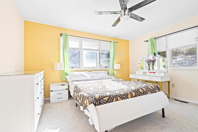 bedroom featuring light carpet, ceiling fan, visible vents, and baseboards