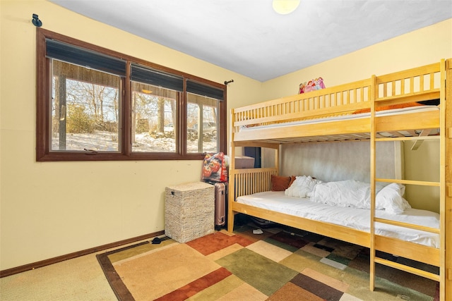 bedroom featuring carpet, multiple windows, and baseboards