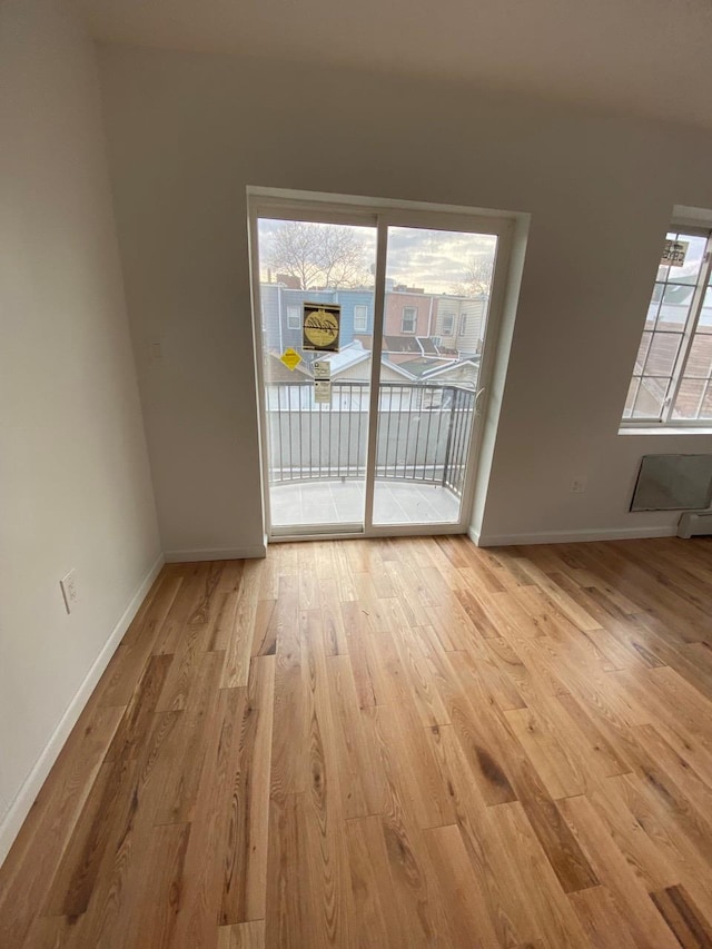 empty room featuring light wood-type flooring and baseboards