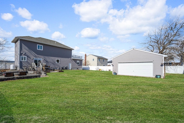 view of yard with a detached garage, fence, and an outdoor structure