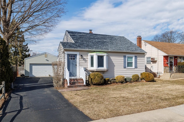 view of front of property featuring an outbuilding, aphalt driveway, a shingled roof, a front lawn, and a wall mounted air conditioner