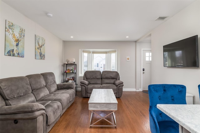 living area featuring recessed lighting, visible vents, baseboards, and wood finished floors