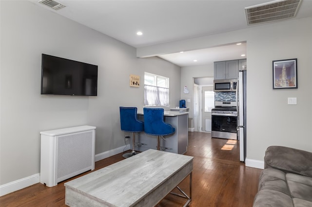 living area featuring dark wood-style floors, baseboards, and visible vents