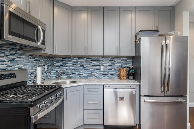 kitchen featuring gray cabinets, stainless steel appliances, and a sink