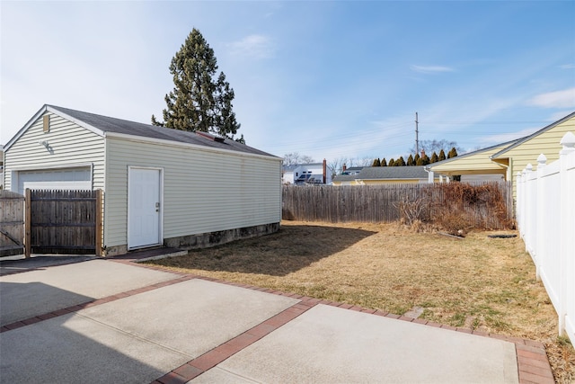 exterior space featuring a patio area, a detached garage, fence, and an outdoor structure