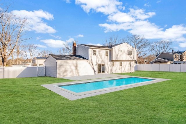 back of property with a lawn, a fenced backyard, and a fenced in pool