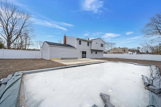 back of house with a fenced backyard and a patio