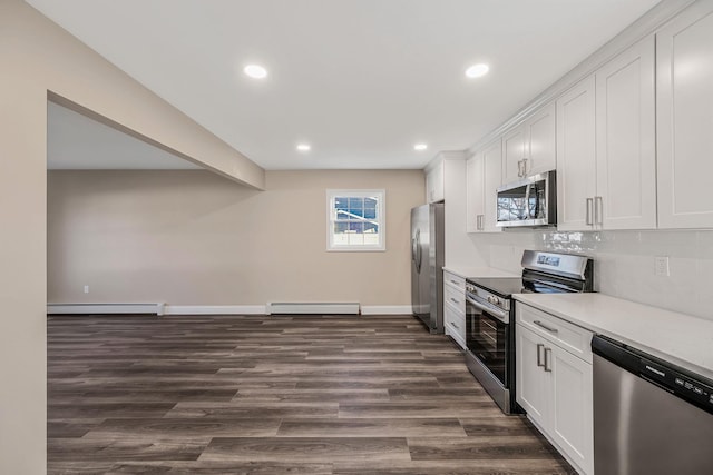 kitchen with stainless steel appliances, a baseboard radiator, and white cabinets