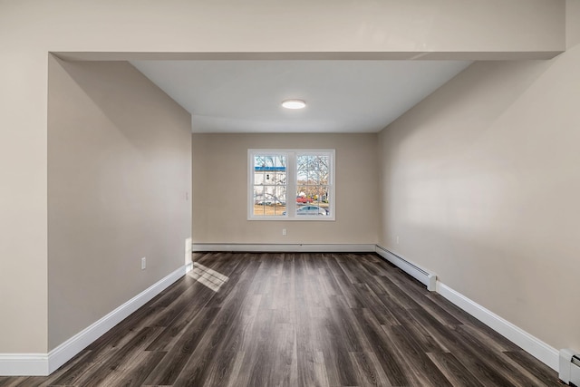 empty room featuring dark wood-style floors, baseboards, and a baseboard heating unit