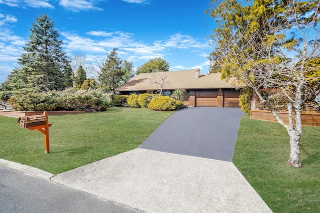 view of front of property with driveway, a front lawn, and an attached garage