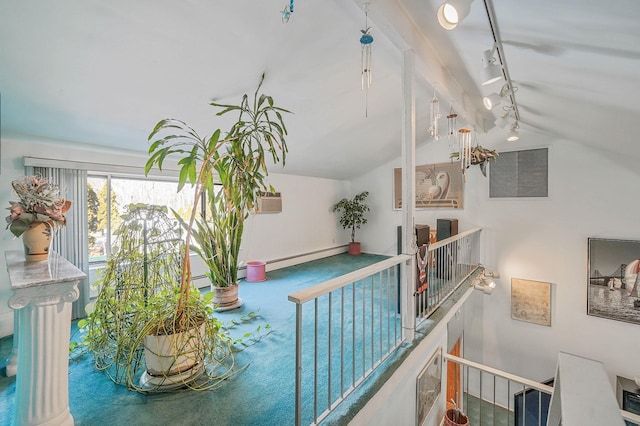 interior space featuring vaulted ceiling, a baseboard radiator, and rail lighting