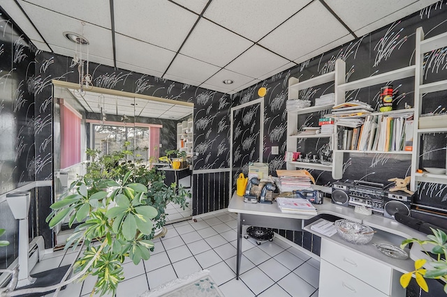 tiled office space with wallpapered walls and a drop ceiling