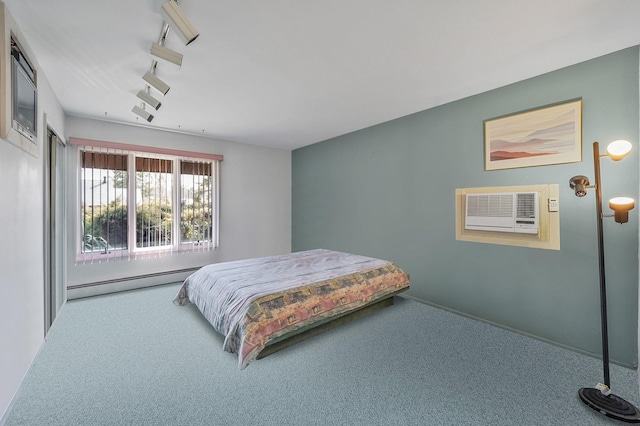 bedroom featuring track lighting, a baseboard radiator, a wall mounted air conditioner, and carpet