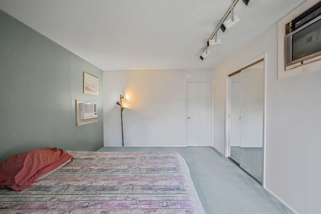 bedroom with a closet, carpet, an AC wall unit, and track lighting