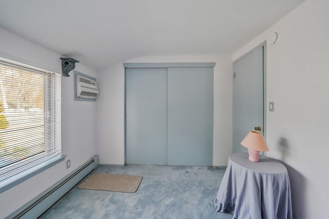 bedroom featuring a baseboard heating unit, a closet, carpet, and a wall unit AC