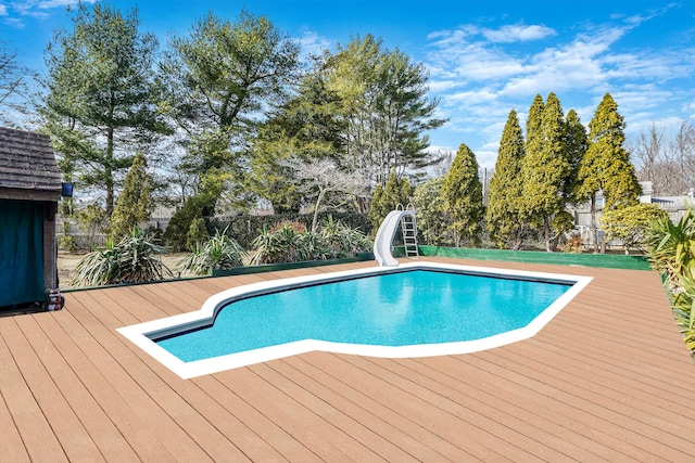 view of pool with a fenced in pool, a water slide, fence, and a wooden deck