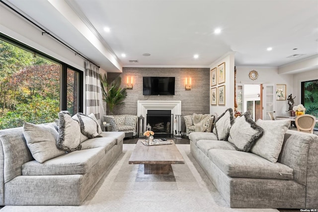 living room featuring ornamental molding, recessed lighting, visible vents, and a fireplace