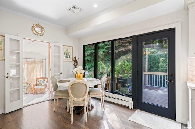 dining area featuring crown molding, visible vents, a baseboard heating unit, wood finished floors, and plenty of natural light