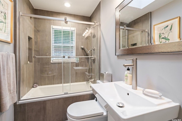 bathroom with tiled shower / bath combo, a skylight, and toilet