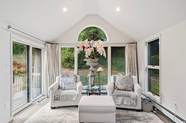 sunroom with vaulted ceiling and a baseboard heating unit