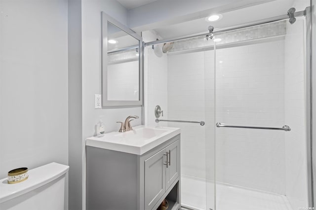 full bathroom with vanity, a shower stall, and toilet