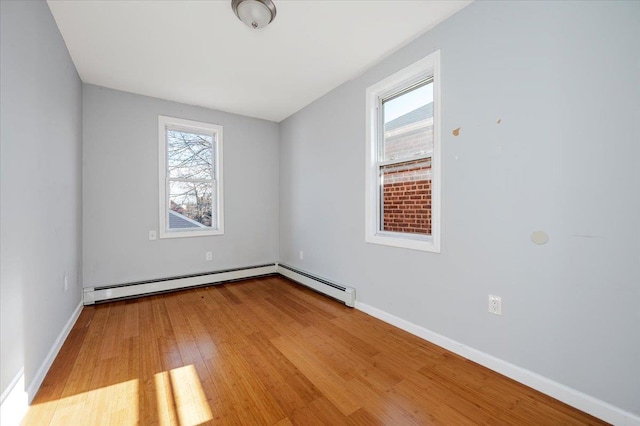 unfurnished room featuring light wood-style flooring, baseboards, and a wealth of natural light