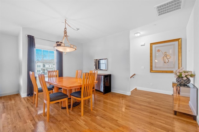 dining room featuring visible vents, light wood-style flooring, and baseboards