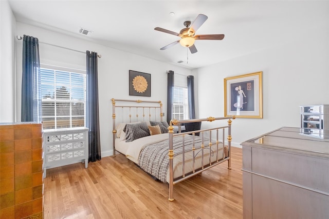 bedroom with visible vents, light wood-style flooring, and multiple windows