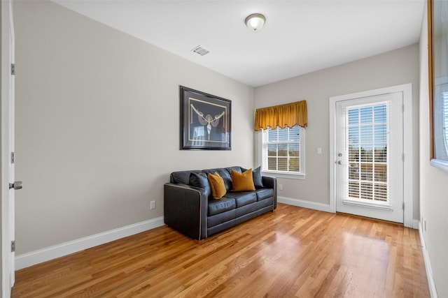 sitting room with light wood finished floors, visible vents, and baseboards