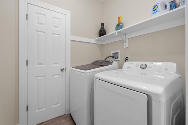 washroom featuring laundry area, washing machine and dryer, and tile patterned floors