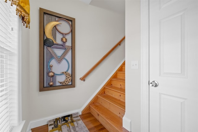 stairway with baseboards and wood finished floors