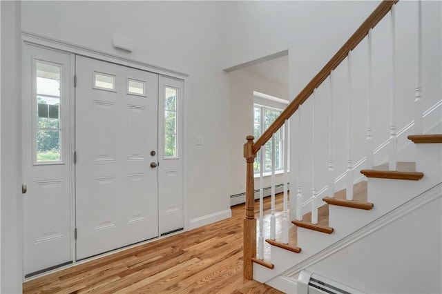 foyer with light wood-style flooring, stairway, a baseboard radiator, baseboards, and baseboard heating