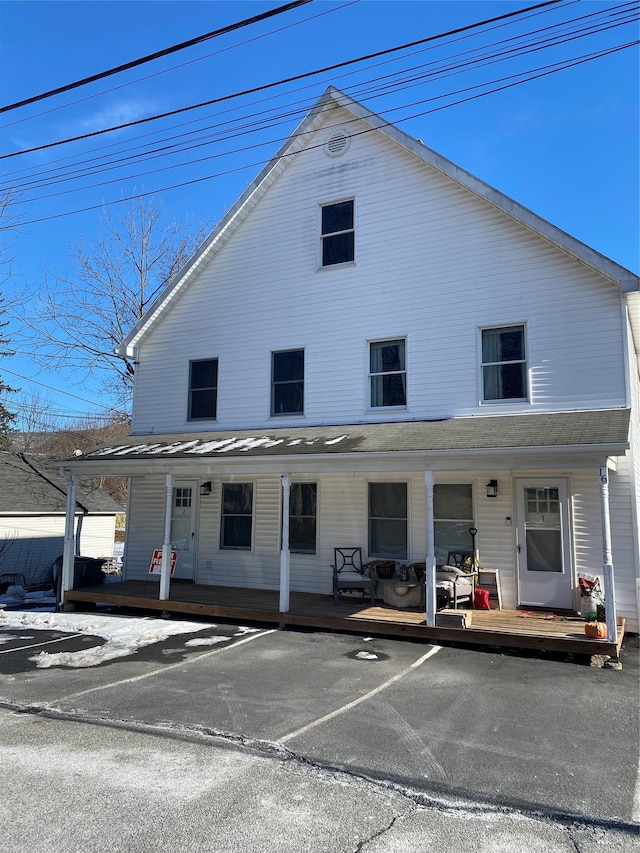 view of front of house featuring a porch and uncovered parking