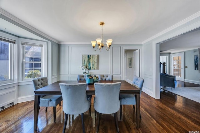 dining room with dark wood-style floors, ornamental molding, and a decorative wall