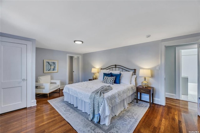 bedroom with dark wood-type flooring and baseboards