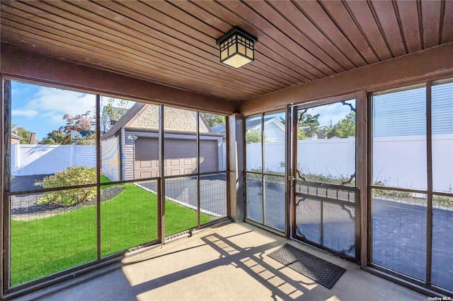 unfurnished sunroom featuring wood ceiling and a wealth of natural light