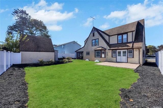 rear view of house featuring a patio area, a lawn, a fenced backyard, and stucco siding