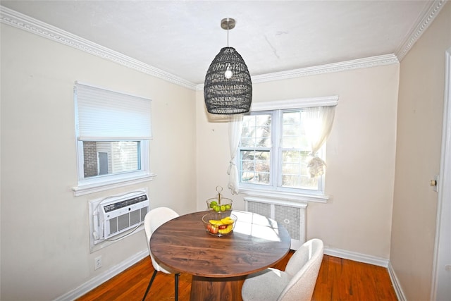 dining area with radiator, crown molding, baseboards, and wood finished floors