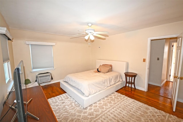 bedroom with wood finished floors, a ceiling fan, and baseboards