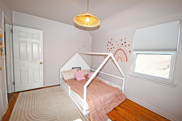 bedroom with baseboards and wood finished floors