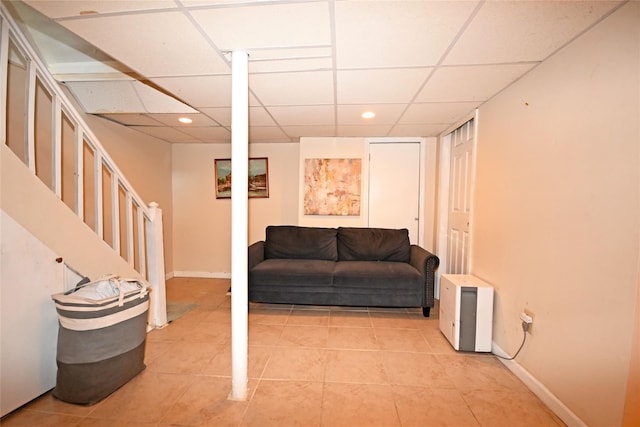 finished below grade area with light tile patterned floors, baseboards, a drop ceiling, stairs, and recessed lighting