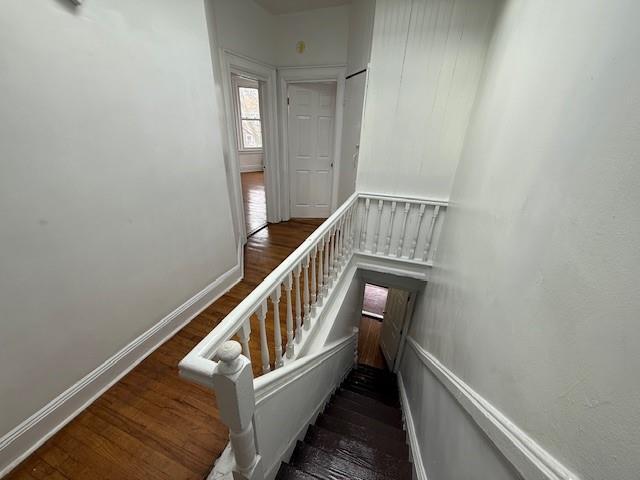 stairway with baseboards and wood finished floors