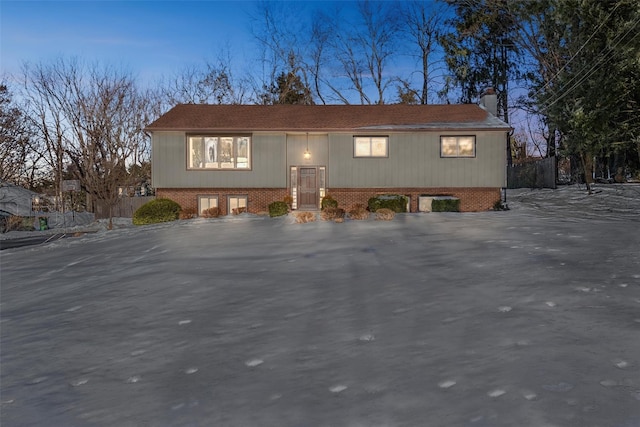 raised ranch with brick siding and a chimney