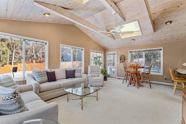 living room with a baseboard heating unit, beamed ceiling, a skylight, and light carpet