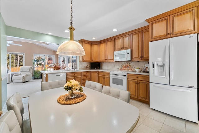 kitchen with pendant lighting, white appliances, light countertops, and a peninsula