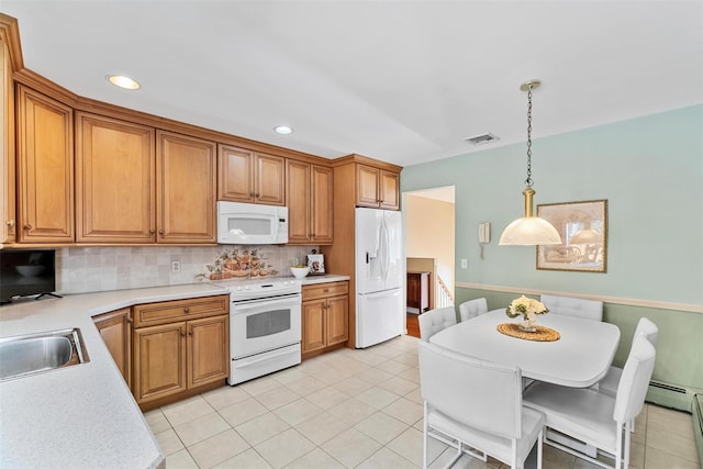 kitchen featuring white appliances, light countertops, hanging light fixtures, and decorative backsplash