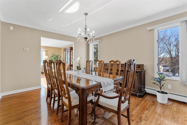 dining area with light wood-style floors, a healthy amount of sunlight, and crown molding